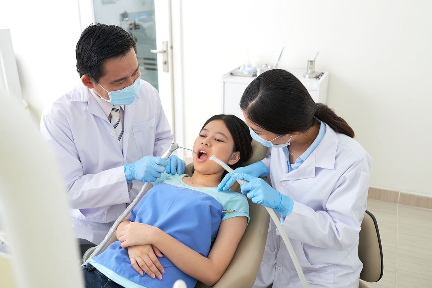 Dental professionals at Carpinello Orthodontics in Edgmont, PA adjust a young patient’s orthodontic appliances.