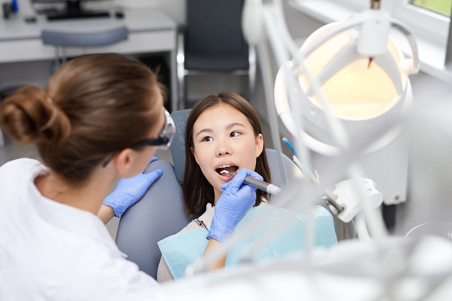 A dentist at Carpinello Orthodontics in Newtown Square, PA, examines a patient and discusses orthodontic appliances.