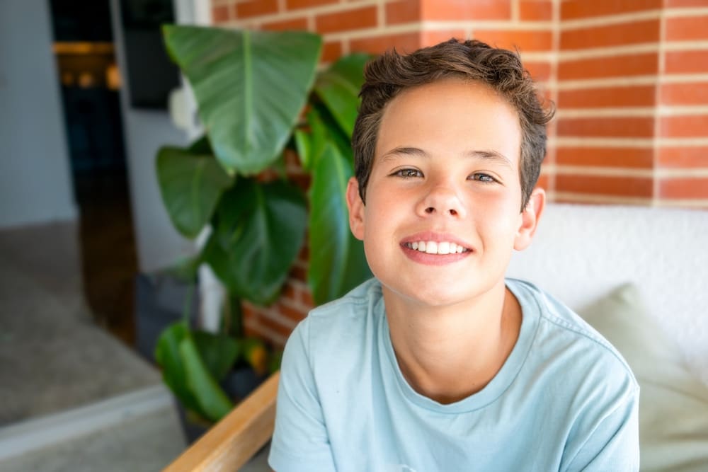 A smiling boy with braces and short brown hair at Carpinello Orthodontics in Drexel Hill, PA.