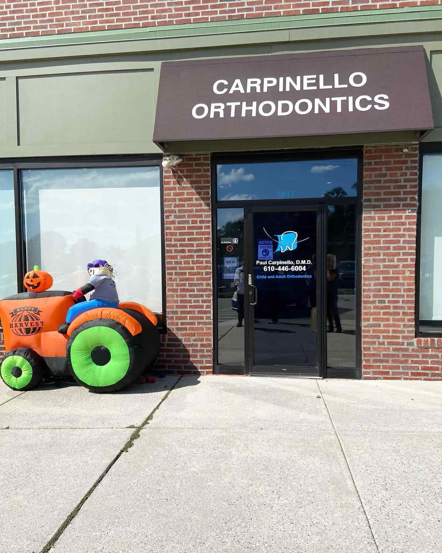 Outside Carpinello Orthodontics in Drexel Hill, Newtown Square or Edgmont, PA, a brick building displays Halloween inflatables.