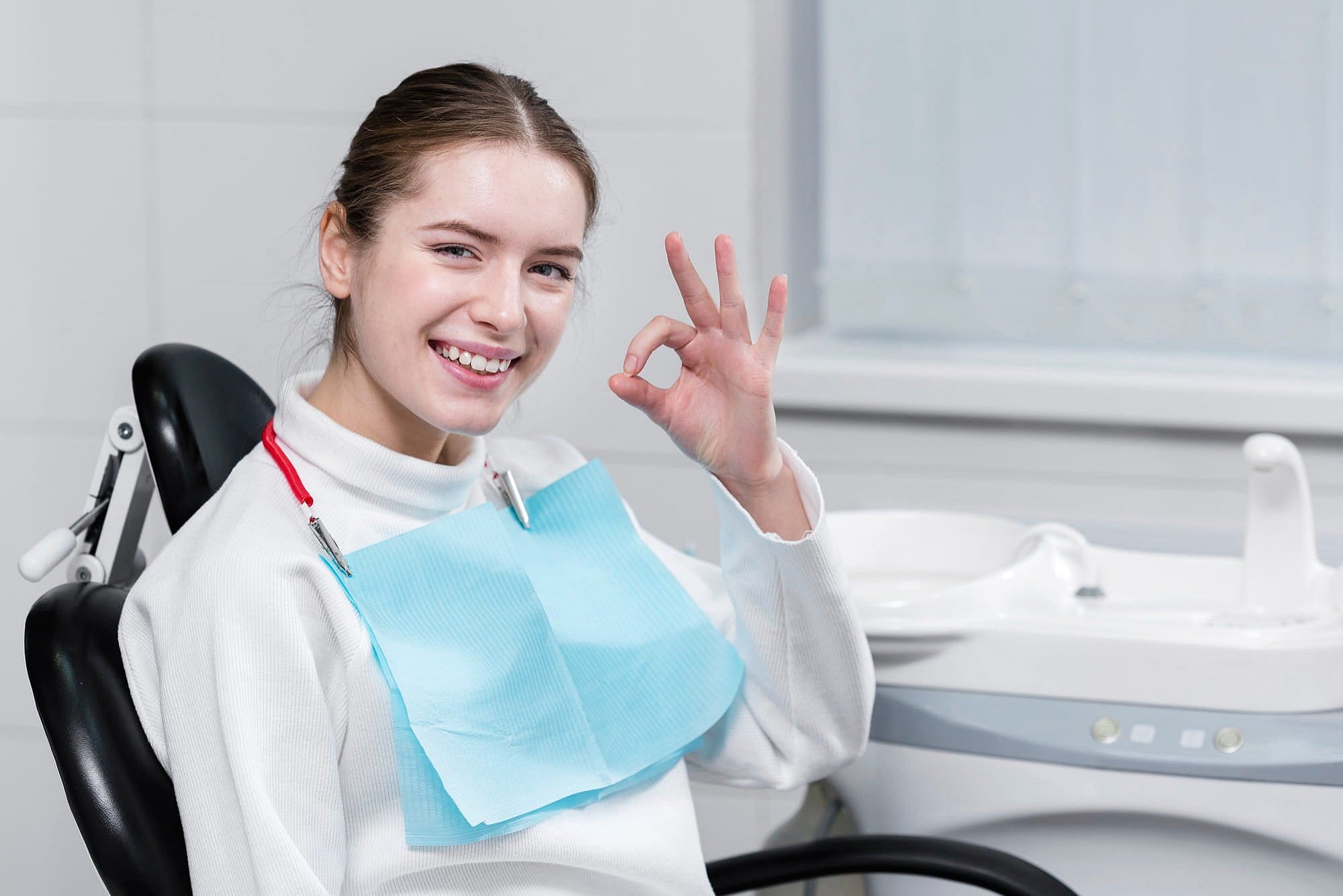 A smiling woman in a dental chair gives an "OK" for Orthodontist at Carpinello Orthodontics in Newtown Square, PA.