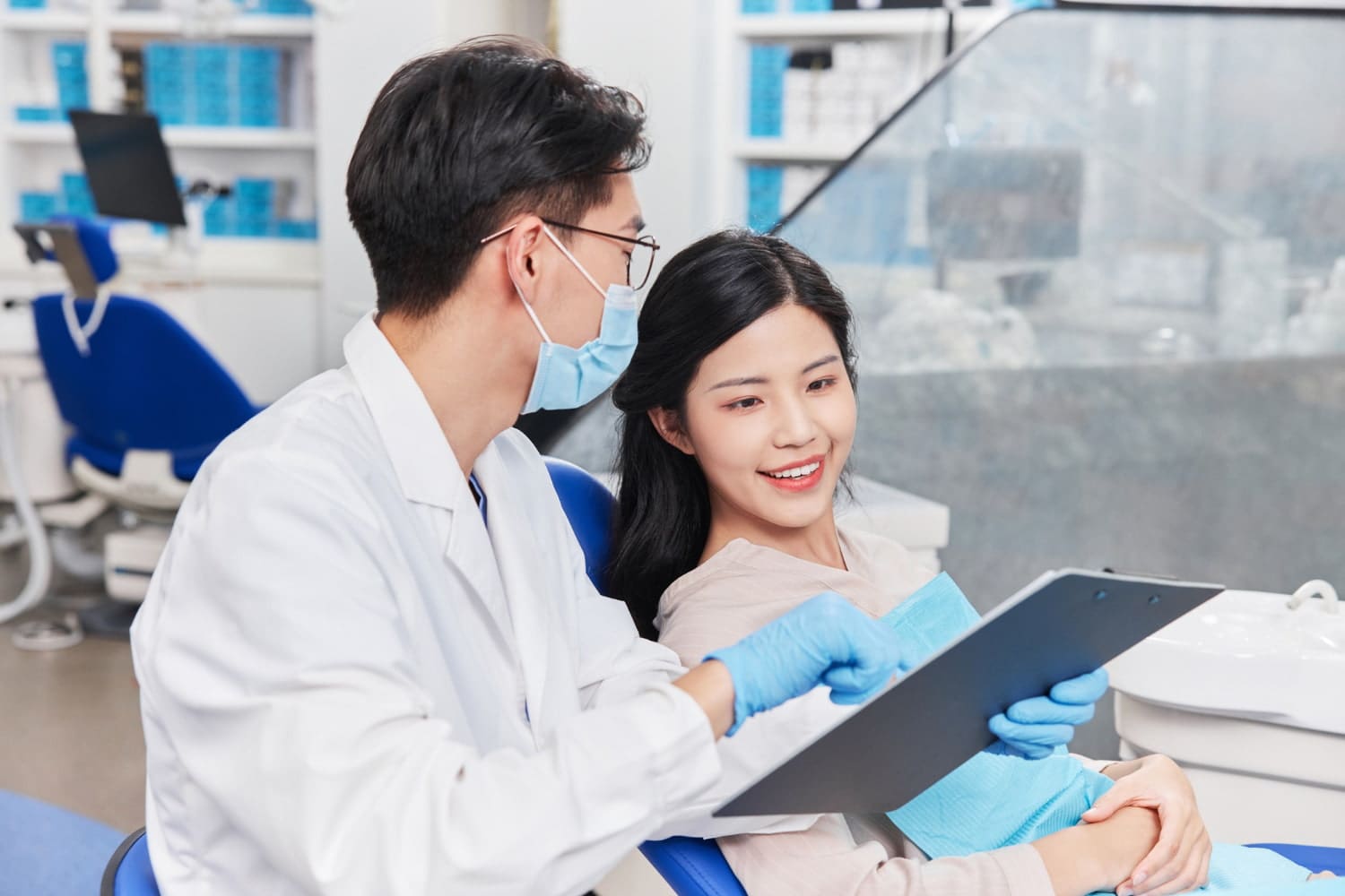 At Carpinello Orthodontics in Drexel Hill, PA, an orthodontist shows a clipboard to a female patient.