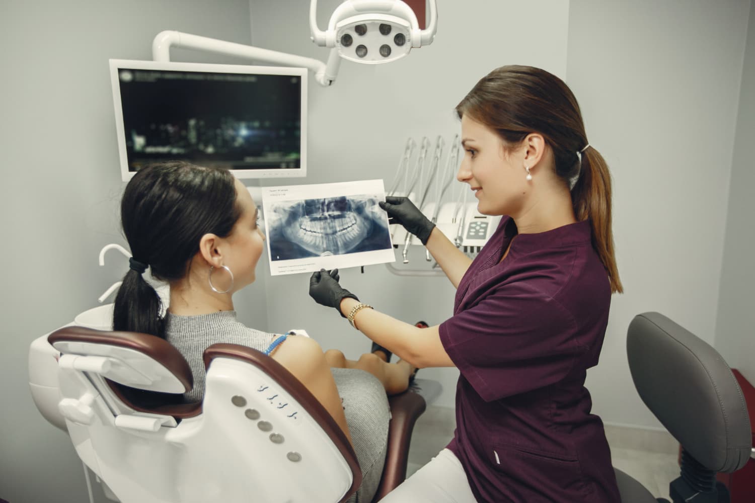 During a consultation at Carpinello Orthodontics in Drexel Hill, Newtown Square or Edgmont, PA, a dentist shows a patient an X-ray to explain jaw surgery benefits.