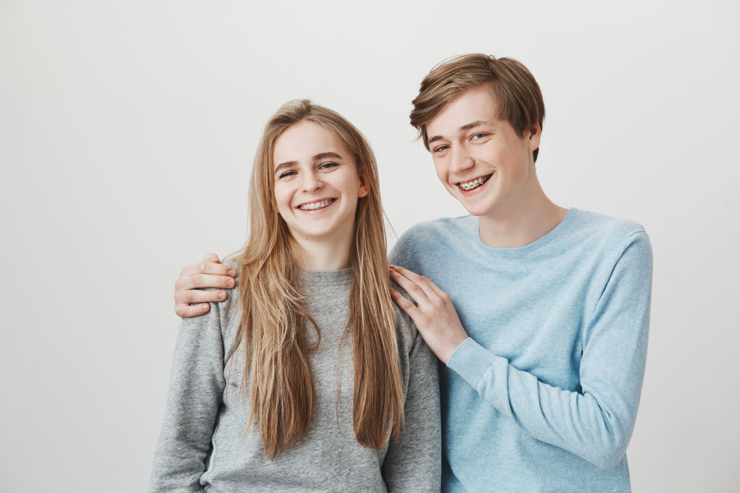 Smiling teens represent affordable braces at Carpinello Orthodontics in Drexel Hill, Newtown Square, or Edgmont, PA; she wears gray, he light blue.