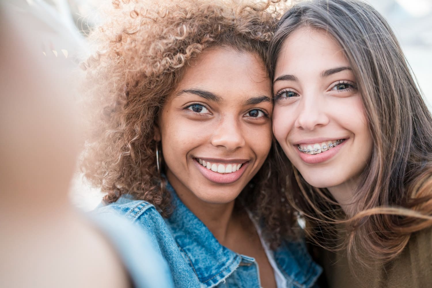 Smiling for a selfie, two women—one with affordable braces—enjoy their visit to Carpinello Orthodontics in Drexel Hill, Newtown Square or Edgmont, PA.