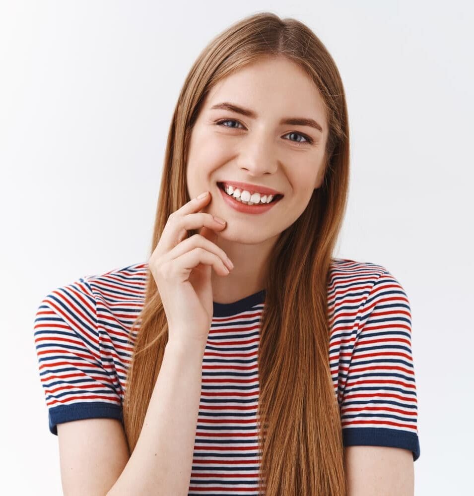 Smiling young woman in striped t-shirt, modeling TMJ mouth guard from Carpinello Orthodontics in Drexel Hill, Newtown Square or Edgmont, PA.