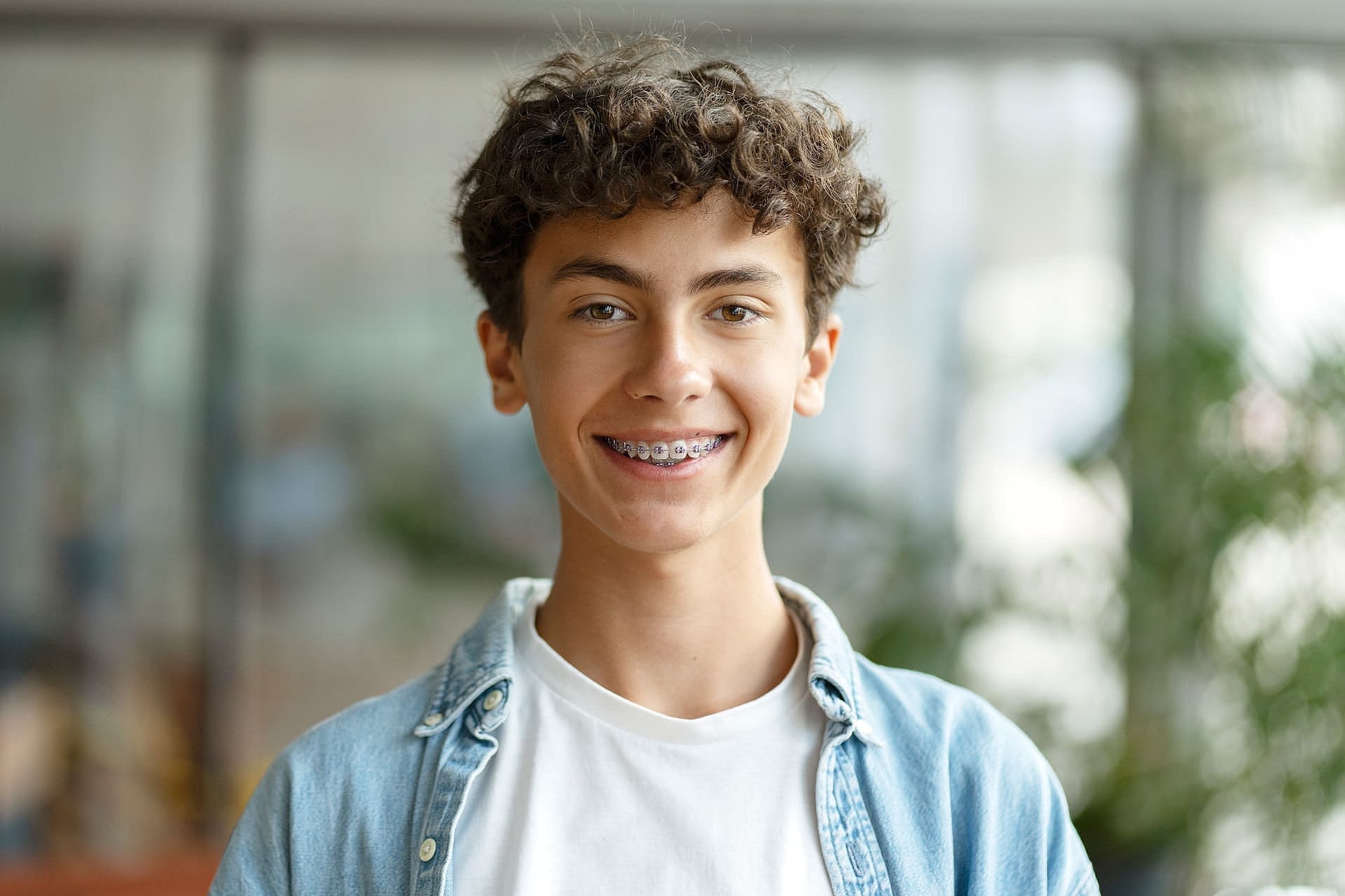 Smiling teen with braces in casual clothes after visiting Children’s Orthodontist at Carpinello Orthodontics in Drexel Hill, Newtown Square or Edgmont, PA.