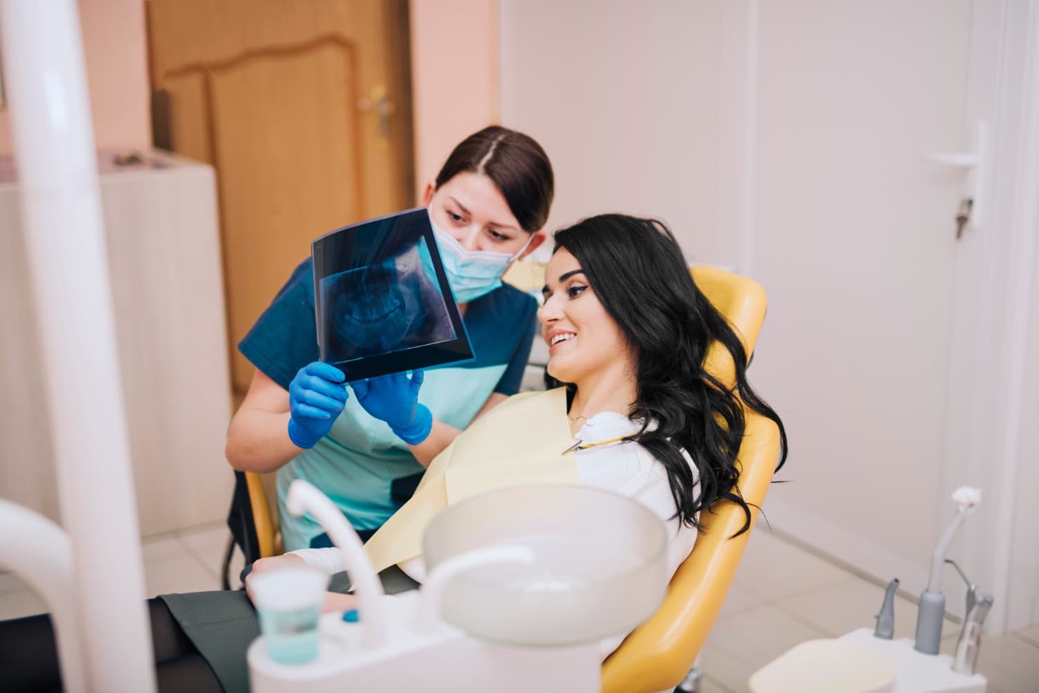 A dental professional at Carpinello Orthodontics in Drexel Hill, Newtown Square or Edgmont, PA reviews an X-ray and metal braces options with a patient.