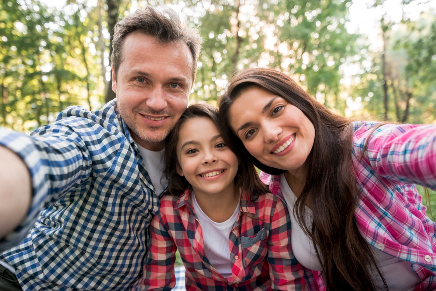 Smiling trio in plaid, selfie outdoors after overbite care by Carpinello Orthodontics in Drexel Hill, Newtown Square or Edgmont, PA.