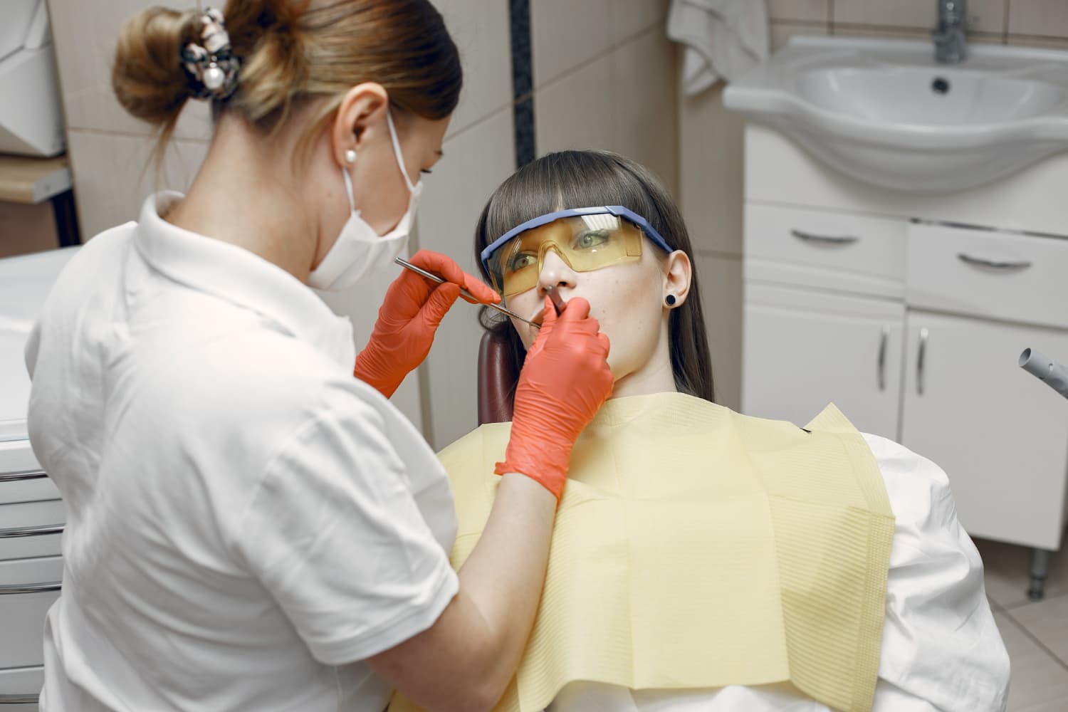 Dentist checks a patient’s Invisalign aligners, showing Invisalign vs braces at Carpinello Orthodontics in Drexel Hill, Newtown Square, or Edgmont PA.