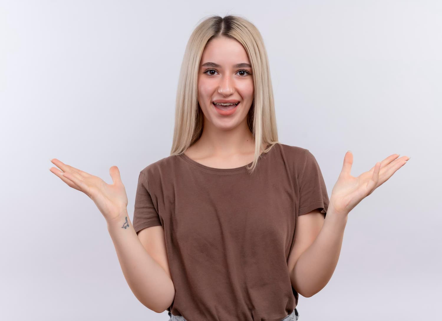 A smiling young woman gestures as if discussing Carpinello Orthodontics braces costs in Drexel Hill, Newtown Square or Edgmont, PA.