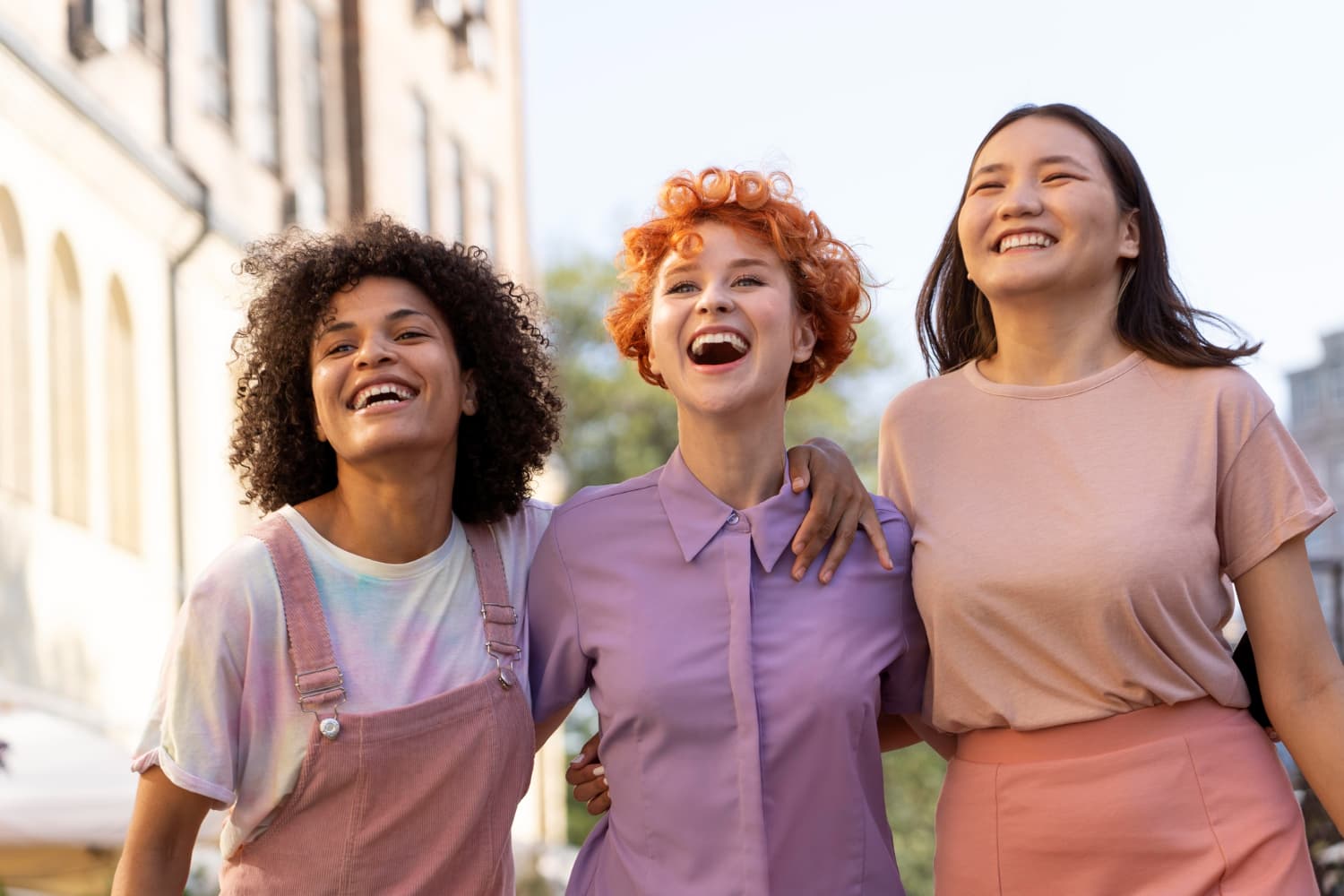 Three women laugh outdoors in pastels, celebrating affordable braces from Carpinello Orthodontics in Drexel Hill, Newtown Square or Edgmont, PA.