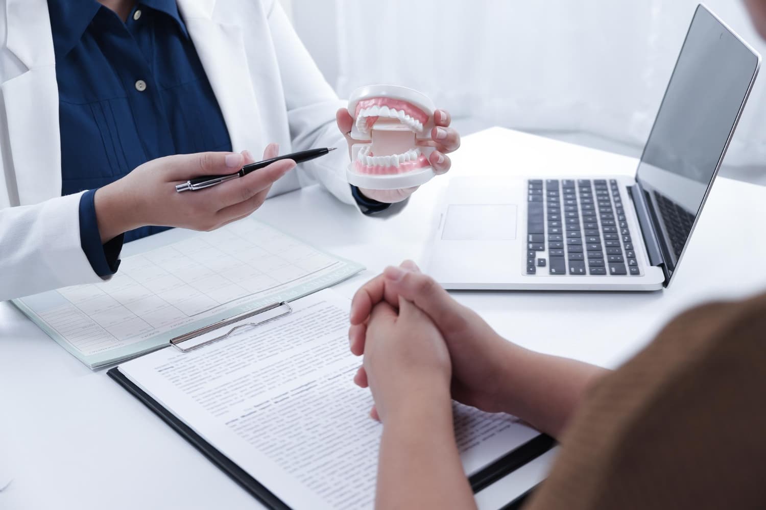 At Carpinello Orthodontics in Drexel Hill, Newtown Square or Edgmont, PA, a dentist explains dental care and insurance to a patient.