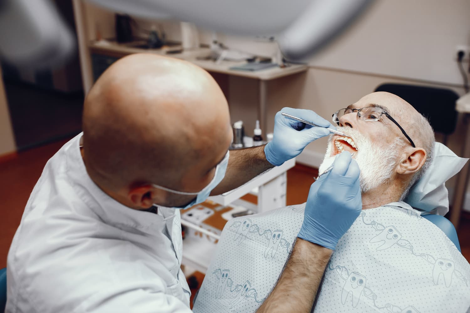 At Carpinello Orthodontics in Drexel Hill, Newtown Square or Edgmont, PA, a dentist checks an older man's teeth for jaw surgery.