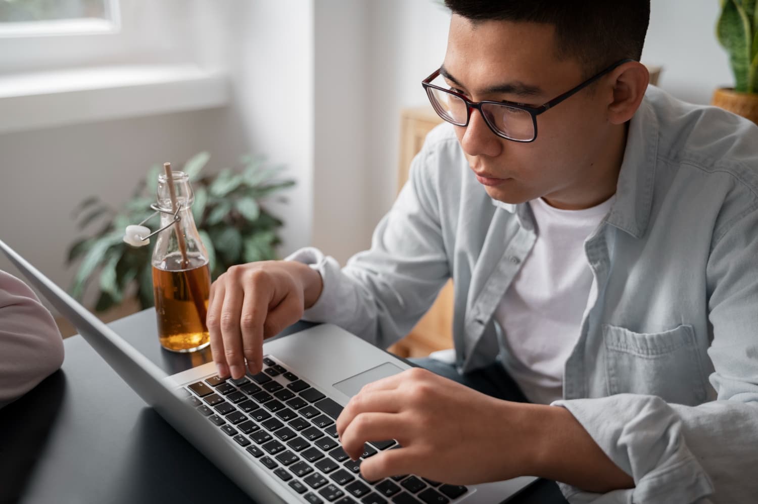 A person with glasses researches affordable braces from Carpinello Orthodontics in Drexel Hill, Newtown Square or Edgmont, PA on a laptop.