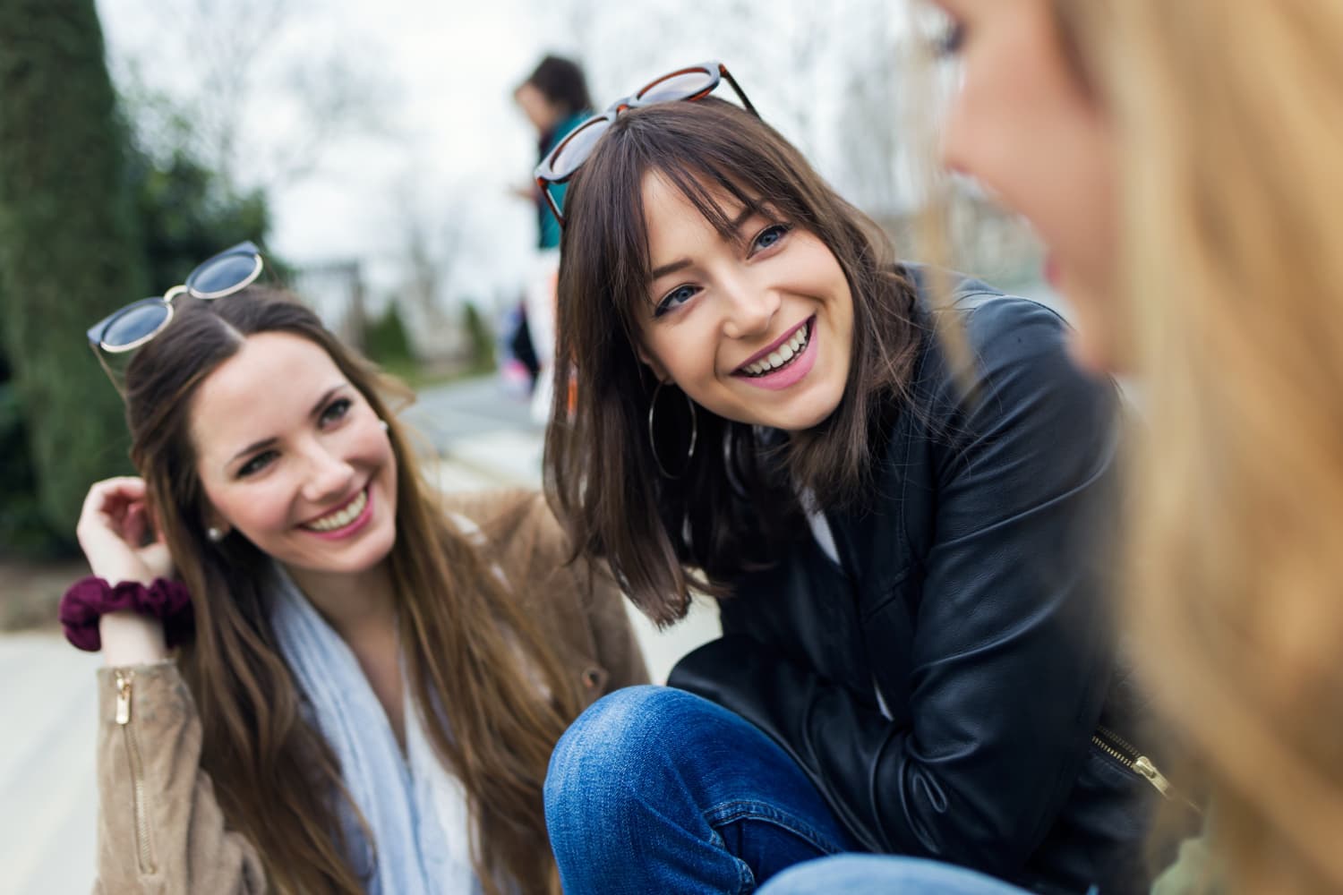 Three young women chat outside; one subtly shows her Herbst Appliance. Carpinello Orthodontics in Drexel Hill, Newtown Square or Edgmont, PA.