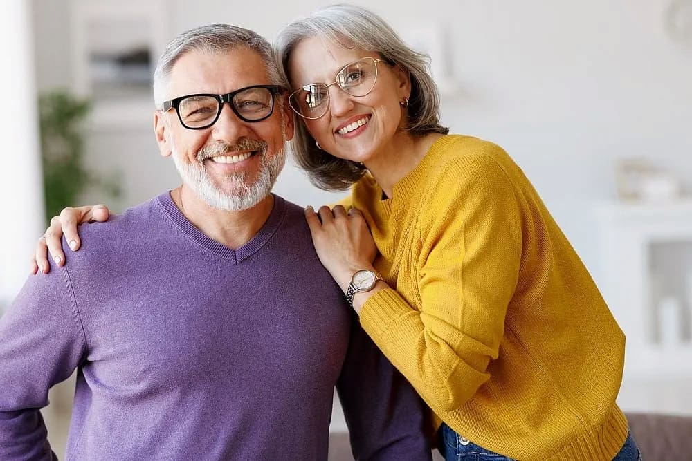 Smiling gray-haired man in blue shirt indoors, representing adult orthodontic treatment at Carpinello Orthodontics in Drexel Hill, Newtown Square, and Edgmont PA.