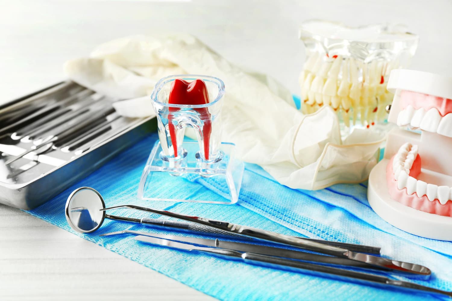 Dental tools, braces model, and dental molds on blue cloth represent Carpinello Orthodontics in Drexel Hill, Newtown Square or Edgmont, PA.