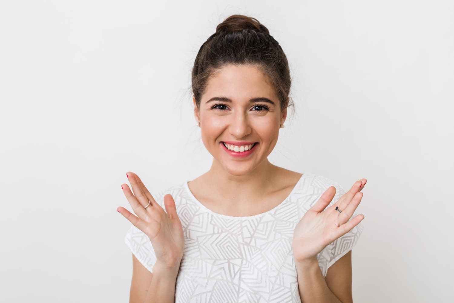 A smiling young woman with a bun radiates confidence after overbite treatment at Carpinello Orthodontics in Drexel Hill, Newtown Square or Edgmont, PA.