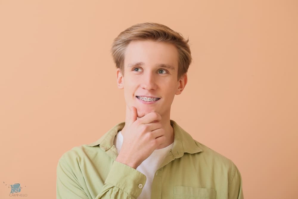 handsome man metal braces color background - How Long Do Braces Take in Drexel Hill, PA 