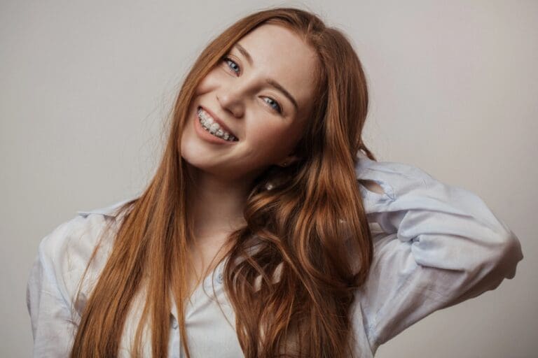 happy young red haired woman in clear braces smiling - Braces for Overbite in Drexel Hill, Edgmont, and Marple Newtown, PA