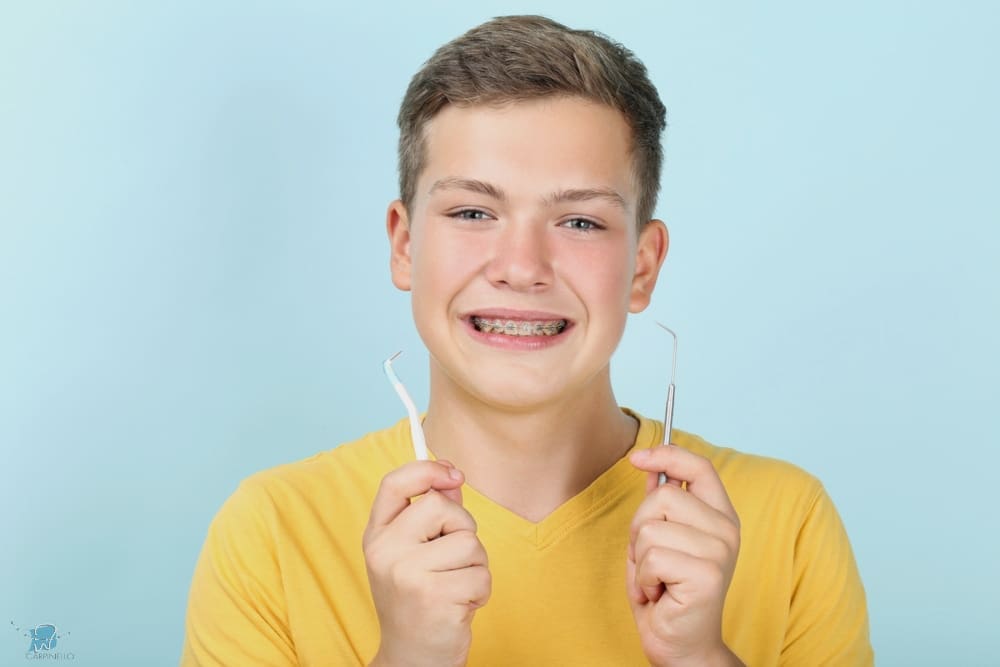 young man with metal braces toothbrush dentist tool - How to Floss with Braces in Drexel Hill, Newtown Square, and Edgmont, PA  